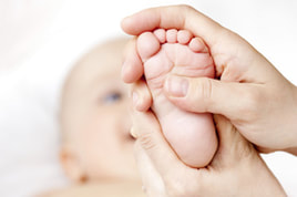 an adult holding a baby's foot | Song's Acupuncture & Herbal Clinic | John Song